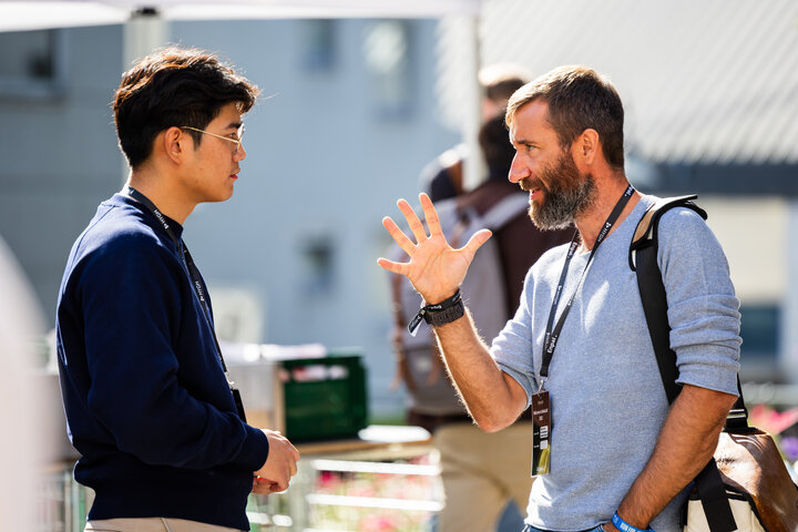 Two men chatting at an outdoor event.